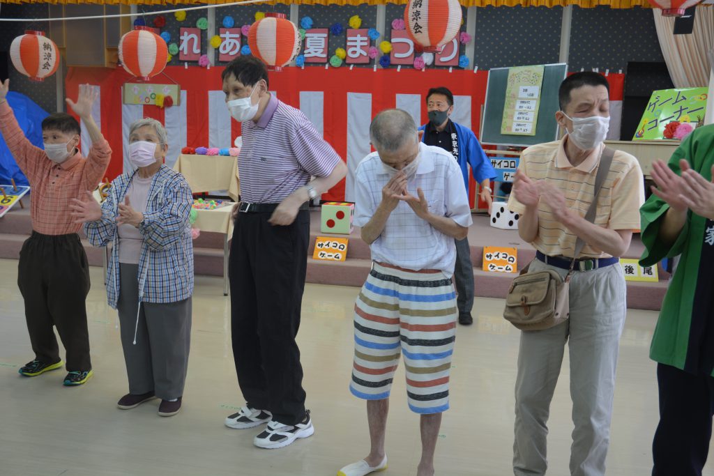 講堂で盆踊りを踊る利用者達の写真