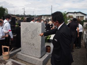 墓碑の言葉を説明する理事長