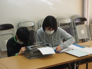 点字学習中の利用者と職員